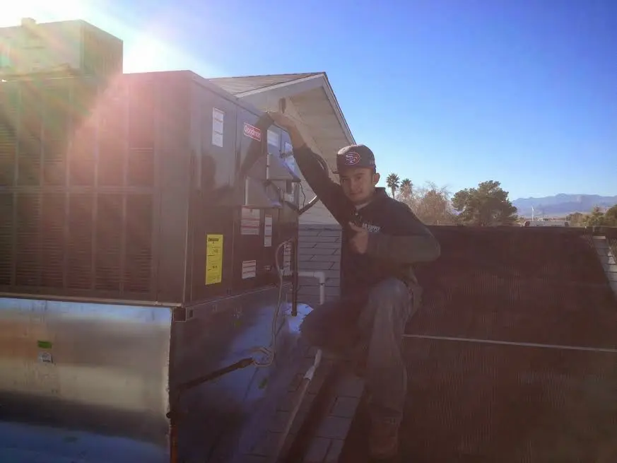 HVAC technician performing Air Duct Repair on a rooftop unit in Woodinville